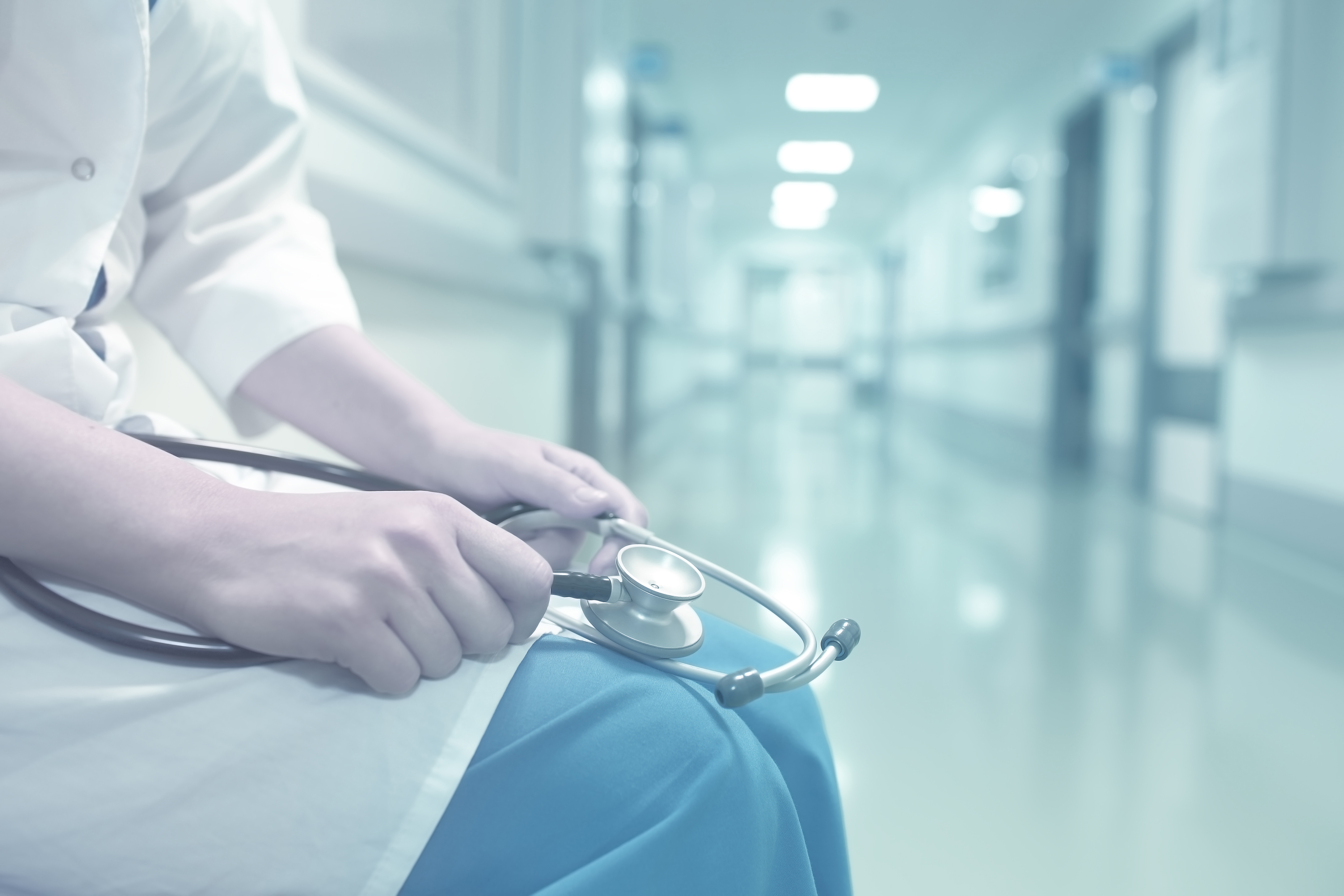 Medical doctor in empty hospital corridor.